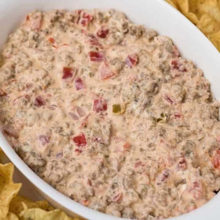 Warm creamy sausage cheese dip with melted cheese and sausage bits served with breadsticks